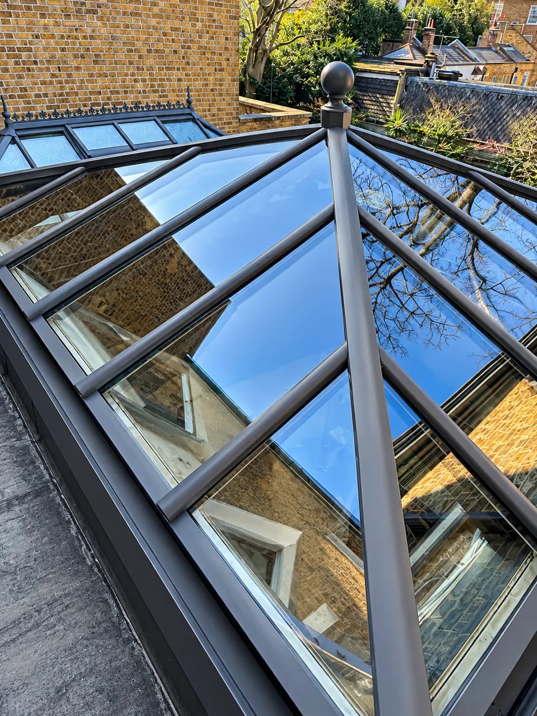 Looking straight up through a freshly cleaned glazed roof lantern, reflecting the surrounding houses.